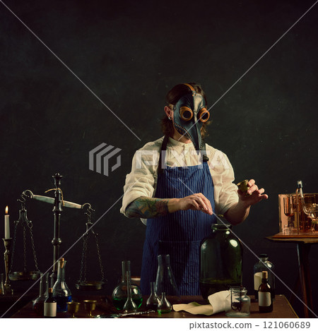 Doctor, carefully measuring herb into large jar,appears to be creating tincture or infusion, surrounded by classic laboratory tools. Doctor, carefully measuring herb into large jar,appears to be creating tincture or infusion, surrounded by classic laboratory tools. 121060689