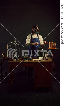 Carefully measuring herb into large jar, plague doctor appears to be creating tincture or infusion, surrounded by classic laboratory tools. 121060690
