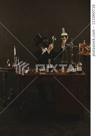 Plague doctor exam green liquid in flask, blending science fiction with historical themes in vintage laboratory against dark mystery background. 121060716