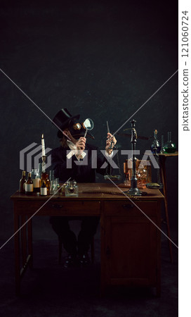 Plague doctor in traditional attire examines mysterious vial, surrounded by array of antique medical tools and glass containers in vintage laboratory 121060724