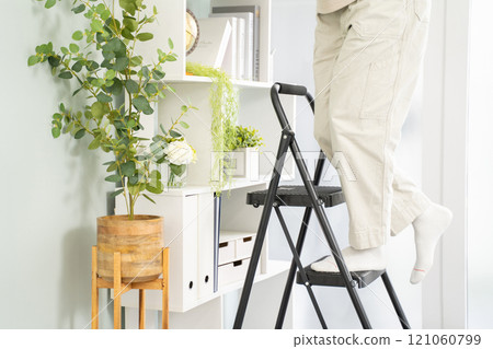 Man climbing a stepladder 121060799