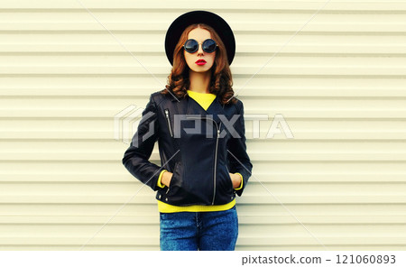 Fashionable portrait of stylish young woman posing in black rock style jacket on white background Fashionable portrait of stylish young woman posing in black rock style jacket on white background 121060893