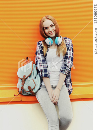 Fashion pretty smiling girl with headphones listens to music in city Fashion pretty smiling girl with headphones listens to music in city 121060978