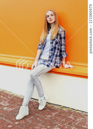 Fashion pretty woman in city over colorful orange background Fashion pretty woman in city over colorful orange background 121060979