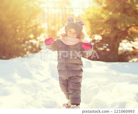 Winter happy smiling little child playing in sunny day 121060993