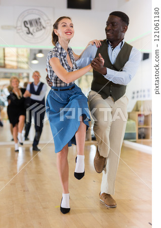 Man and woman performing jazz dance in dancing room 121061180