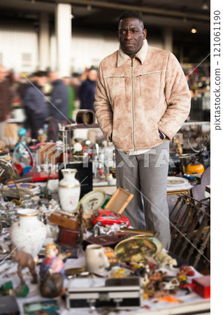Ordinary african american guy sells things at a flea market 121061190