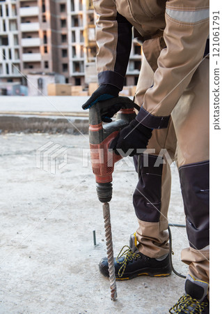 Construction Worker Using Power Drill on Site 121061791