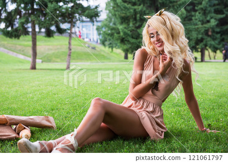Beauty blonde young woman resting in the park Beauty blonde young woman resting in the park 121061797