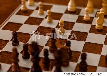 A wooden chess board with a black pawn on it A wooden chess board with a black pawn on it 121063295