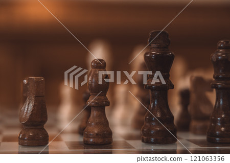 A chess board with wooden pieces on it 121063356
