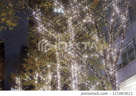 Illuminated tree-lined street photographed with a cross filter 121063621