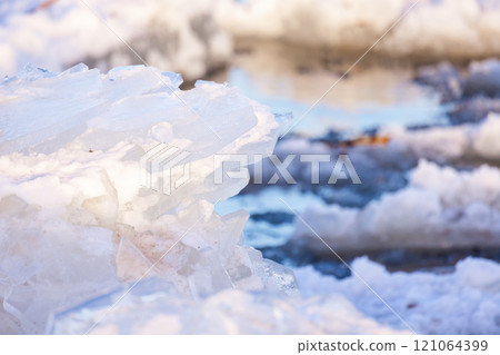 Melting ice shards lay at the coast of frozen sea on a winter day Melting ice shards lay at the coast of frozen sea on a winter day 121064399