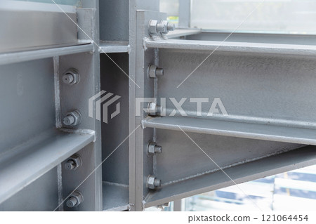 Gray metal girders connected with bolts, close-up photo 121064454