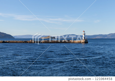 Lighthouse tower is mounted at the end of stone breakwater Lighthouse tower is mounted at the end of stone breakwater 121064458