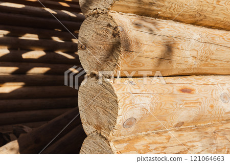 Wall of a new wooden house made of uncolored natural pine tree logs 121064663