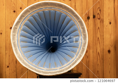 Decorated blue gramophone speaker is over wooden wall Decorated blue gramophone speaker is over wooden wall 121064697