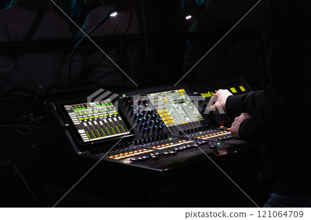 Hands of a sound engineer working at a mixing console, close-up Hands of a sound engineer working at a mixing console, close-up 121064709