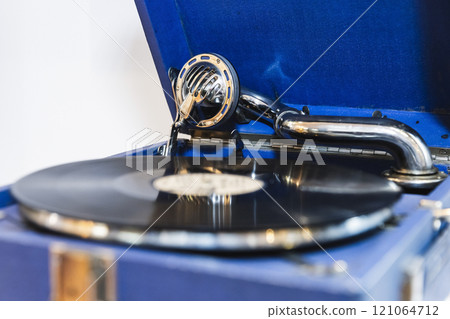 Blue vintage phonograph with black vinyl record plays an old music 121064712