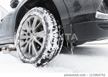 SUV car wheel on snow tire with metal studs, close-up photography SUV car wheel on snow tire with metal studs, close-up photography 121064742