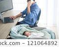 A father working remotely from home with a smartphone while raising a baby 121064892