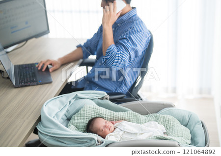A father working remotely from home with a smartphone while raising a baby 121064892