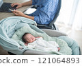 A father working remotely from home with a smartphone while raising a baby 121064893