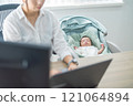 A mother who works remotely from home while raising her baby 121064894
