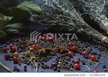 various spices scattered on a dark background with bunches of grass, laurel leaves, berries and other spices for cooking fragrant Eastern and Midwestern food. High quality photo various spices scattered on a dark background with bunches of grass, laurel leaves, berries and other spices for cooking fragrant Eastern and Midwestern food. High quality photo 121065205