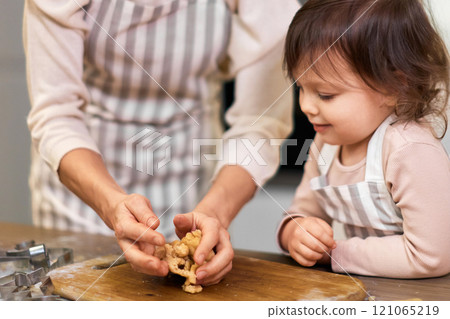 family mother and little child daughter kneading shortbread dough in kitchen 121065219