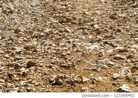 Background of coarse gravel and stone road in sunlight, coarse rocky gravel road in rural area Background of coarse gravel and stone road in sunlight, coarse rocky gravel road in rural area 121066402