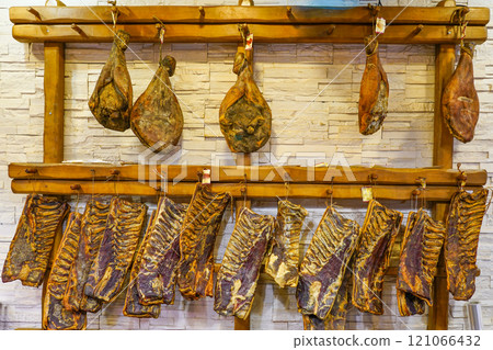 Dried and smoked hams and ribs hang in a traditional butcher shop in a small Croatian town Dried and smoked hams and ribs hang in a traditional butcher shop in a small Croatian town 121066432