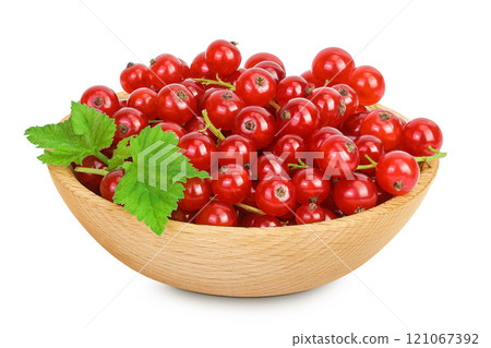 Red currant berries in a wooden bowl isolated on white background Red currant berries in a wooden bowl isolated on white background 121067392