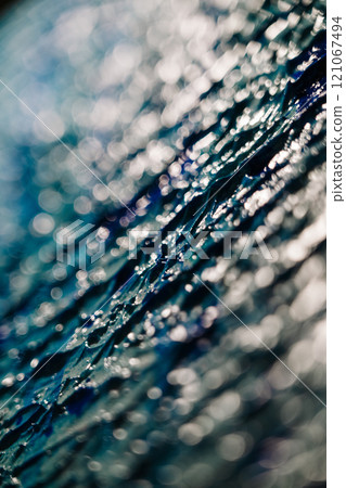 Closeup of a blue glass fragment with a blurred background 121067494