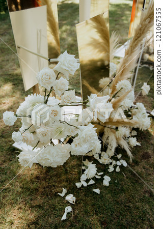 White flowers sit on the ground in front of a mirror 121067555