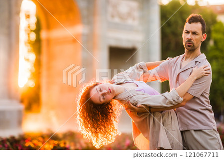 Dancers performing swing dance at puerta de alcala in madrid at sunset 121067711