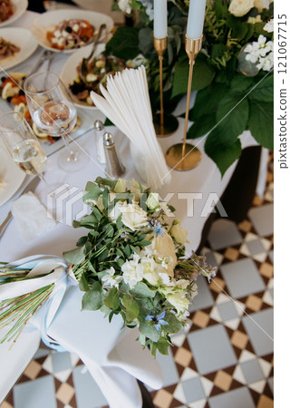 A decorated table with a stunning flower bouquet and elegant candles 121067715