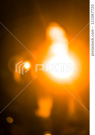 Blurred bright lights creating warm orange glow Blurred bright lights creating warm orange glow 121067720