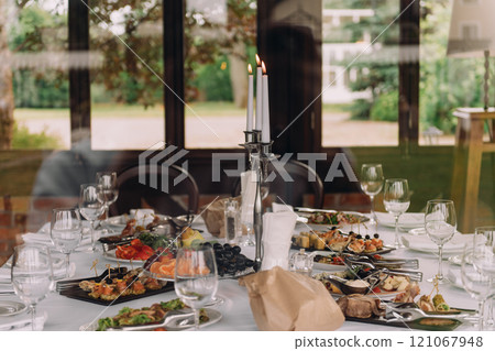 A beautifully arranged table is set with delightful food and wine A beautifully arranged table is set with delightful food and wine 121067948