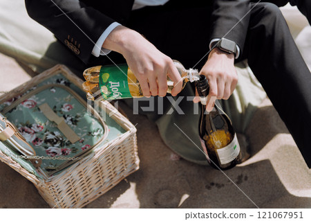 A welldressed man wearing a suit is skillfully opening a bottle of champagne A welldressed man wearing a suit is skillfully opening a bottle of champagne 121067951