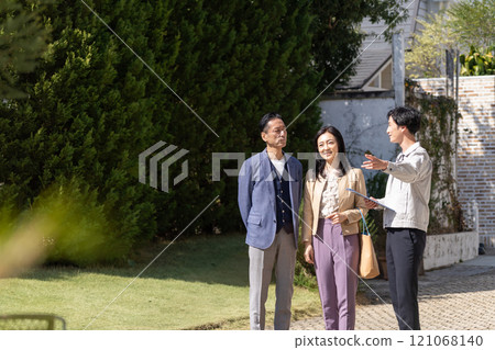 A businessman and a middle-aged couple having a meeting about renovation 121068140