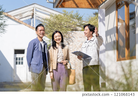 A businessman and a middle-aged couple having a meeting about renovation 121068143