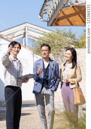 A businessman and a middle-aged couple working at a construction site 121068151