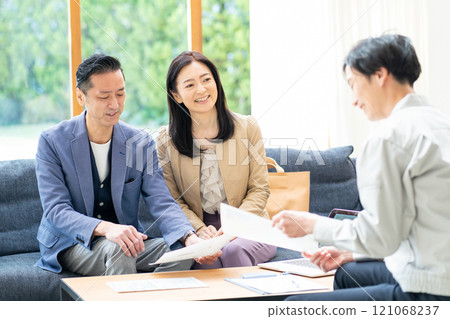 A businessman and a middle-aged couple having a meeting about renovation 121068237