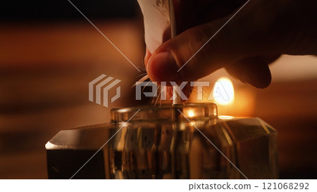 Man Takes Feather Quill Pen From Inkwell. Warm Glow Light Of Old Candle. Books 121068292