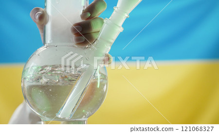Woman Smoking Medical Marijuana, Glass Water Bong On Ukrainian Flag Background 121068327