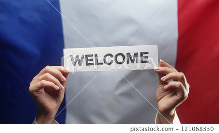 Woman With Welcome Lettering Title Text Cardboard On French Flag Background Woman With Welcome Lettering Title Text Cardboard On French Flag Background 121068330