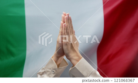 Woman Praying On Italian Tricolor National Flag Background.hopeful Prayer, Italy  121068367