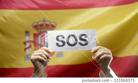 Female Hands With Sos, Alarm, Emergency Card On Spanish National Flag Background Female Hands With Sos, Alarm, Emergency Card On Spanish National Flag Background 121068373