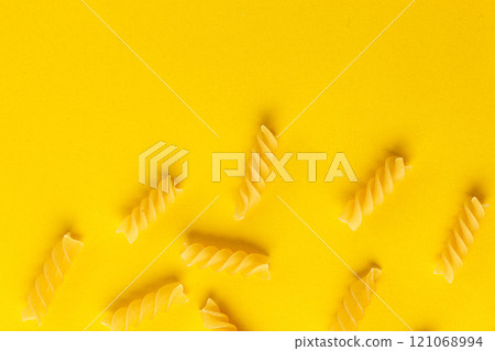 Different types and shapes of dry italian pasta on a yellow background Different types and shapes of dry italian pasta on a yellow background 121068994
